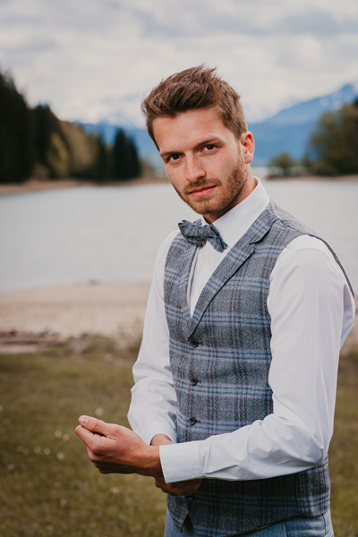 Der Bräutigam in blau-karierter Weste auf der Bergsee-Hochzeit